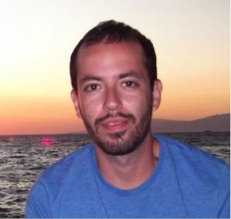 An image of Dr Theo Karamos wearing a blue t-shirt at sun set