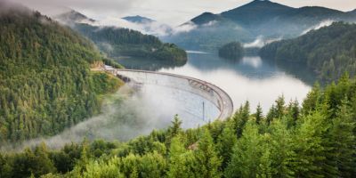 A white bridge and dam between mountains