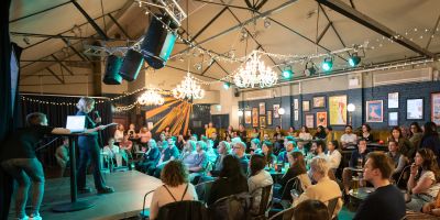 An audience listen to a female speaker at Pint of Science