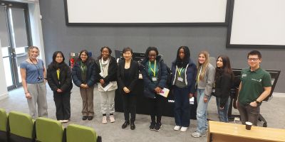 Professor xiaowei zhuang middle and students smile at the camera
