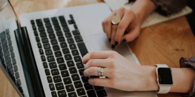 Two hands lying on a laptop keyboard.