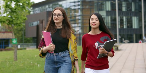 two female students, walking through campus