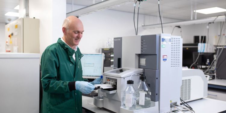 Scientist standing in front of a machine