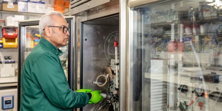 Scientist standing in front of a Protein Expression and Purification machine