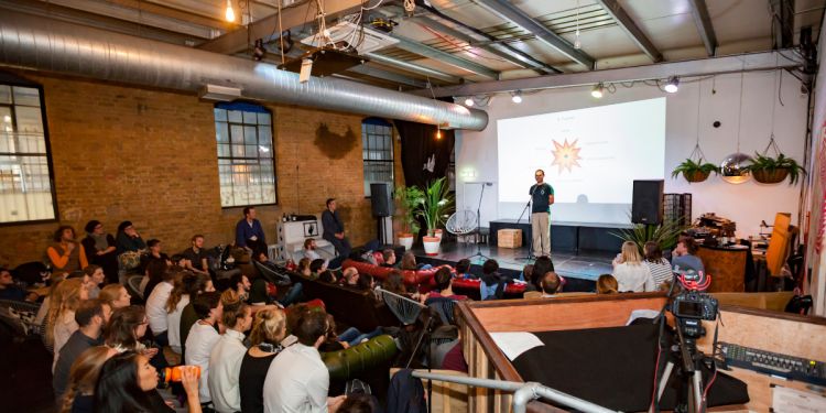 An audience listen to a male speaker at a Pint of Science event 